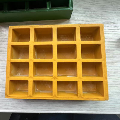 Ağ boyutu 38x38mm, sarı renkte FRP kalıplı ızgara, bir tarafında kapaklı düz yüzey.